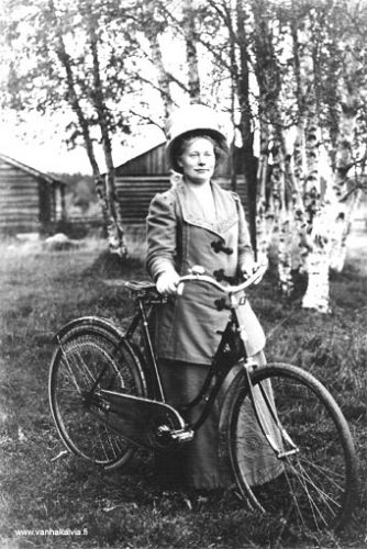 Lilia Kleemola vuonna 1913
Lilia Kleemola oli syntynyt Heikkiniemessä, Ruotsalolla 11.11.1884.  Lilia meni Amerikkaan 1903 ja palasi Kälviälle 1908. Hän perusti kahvilan ja myöhemmin vuonna 1932 rakennutti oman talon Säästöpankin ja Ojanperän kaupan naapuriksi, jossa toimi koko hänen elinikänsä kahvila Kotipuisto. 
Lilian hieno, pyörän kanssa otettu kuva on annettu Ester Salolle Hillin kylään  ja kuvan takana on teksti Onnellista uutta vuotta 1913

Keywords: Kleemola Heikkiniemi USA 