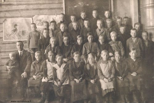 Ruotsalon koululaisia n. 1921
Opettaja Aatu Valkama, sylissä Aatto Johannes (s. 1920, Valkama 16).
Ylhäältä toisessa rivissä 3. vasemmalta Viljo Karhulahti (Karhulahti 31), 5. vas. Oiva Voitto Pietilä (s. 1910, Pietilä 30) ja 3. oikealta Pentti Järvi (s. 1907, Juuret Kälviällä s. 662). Toinen rivi alhaalta käsin, vas. Siiri Kippo (m. Karhulahti, Kippo 29) ja Rauha Rimmi (Rimmi 20), 4. vas. mahdollisesti Matjussi.
Keywords: Valkama Kippo Karhulahti Rimmi Järvi Pietilä Matinjussi 