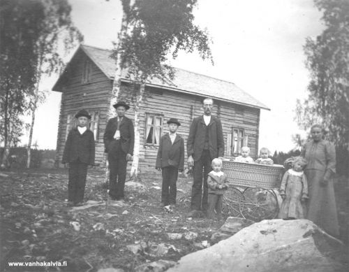 Jukka Luodon perhe
Niemelässä sijaitsevan talon pihalle on asettunut Jukka Luodon perhekunta, lapsista nuorimmaisina kaksoset Elna ja Ester (s. 1905) hienoissa vaunuissa. Pojat ovat nimeltään Eino Johannes (s. 1892), Edvin Vilhelm (s. 1888) ja Eeli Simfrid (s. 1894). Vaunujen edessä oleva pikkupoika on Evald (s. 1903) ja tyttö on Elsa Johanna (s. 1901). Hän meni aikanaan Otto Junnolan kanssa naimisiin. 

Jukka Luoto on ollut Juho Matinpoika Syväjärvi (1858-1929, Syväjärvi 14). Jukka on mennyt Johanna Luodon kanssa naimisiin. Johanna oli leski ja hänellä ennestään lapset Eemil ja Ernst. Heille tuli lapsia, Johanna kuoli, ja Jukka meni vielä uudestaan vuonna 1900 naimisiin Hilma Johanna Junnilan (1877-1939) kanssa, joka on tässä kuvassa. 
 
Rakennuksesta tiedetään, että se on siirretty Niemelään ja siinä on toiminut Peitson kiertokoulu. 
Keywords: Luoto Niemelä Peitso Junnila Syväjärvi Junnola