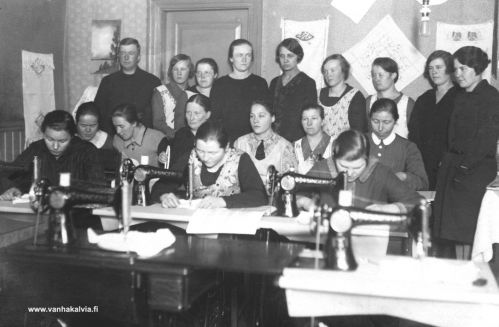 Ompelijoita
Kyseessä on ehkä ompelukurssi. Takana toinen oik. on Anna Koskela (myöh. Hukari, Koskela 18). Keskirivissä 2. oik. Fanni Maunumäki (Maunumäki 38). Eturivissä keskimmäinen henkilö ompelukoneella on mahdollisesti Meeri Elviira Harju ( o.s. Maunumäki, 15.6.1905-16.5.1995, Maunumäki 36).
Jos tunnistat muita henkilöitä,  lähettäisitkö tietoja osoitteeseen outi.jarvi (at) gmail.com. Voit myös ottaa yhteyttä Kälviän kotiseutuyhdistykseen. Kiitos avustasi!
Keywords: Maunumäki Koskela Hukari Harju