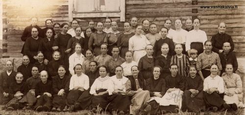 Välikylän äidit 1923
Äitienpäiväkuva Välikylän koululta keväältä 1923. Alarivissä istumassa 6. vas. tummassa asussa Fanny Kotkajuuri (Hietakangas 4). Alhaalta päin toisen rivin oikeanpuoleisessa päässä istuu Vilhelmiina Huhta (o.s. Hakunti, Huhta 18) ja valkopukuinen nainen kolmannessa rivissä alhaalta kuvan keskellä hieman oikealla on Välikylän koulun opettaja Aili Järvi (Järvi 24) 
Toinen rivi ylhäältä (kolmas rivi alhaalta): ensim. vas. Hanna Tuomisalo, kolmas vas. Roosa (Ruusa) Renell, neljäs vas. Lempi Ruokoja (o.s. Nissi). Kahdeksantena vas. kolmannessa rivissä Senni Huhta (o.s. Pajala). Opettaja Aili Järven yläp.vas. Kustin Hanna eli Hanna Aho. 
Alarivi toinen oik. Eedla Haapasalo, neljäs Sofia Rautomäki (o.s. Hilli), viides oik. Lyyti Palo. Alarivi neljäs vas. Mari Pajala (o.s. Maunula). 
Toinen rivi alhaalta ensimm. vas. Sofia Kotka (o.s. Hilli, Saivarheen torpasta), kuudentena vas. mahd. Augustin Selma. Toinen rivi oik. neljäs Lydia Ruokoja (Ollin Lyyti). 

Muut äidit vielä tunnistamatta.  Jos tunnistat äitejä, lähettäisitkö tietoja osoitteeseen vanhat.kuvat@vanhakalvia.fi. Kiitos avustasi!


Keywords: Huhta Hakunti Järvi Haapasalo Rautomäki Hilli Palo Pajala Kotka Ruokoja Tuomisalo Renell Aho Huhta Kotkajuuri