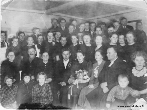 Aune o.s. Herlevi ja Niilo Nummelan hääkuva 26.1.1941
Henkilöt kuvassa: Edessä vasemmalta
Raili, Ritva ja Anni Herlevi
Toinen rivi
Vuomäen mummo Loviisa Niemi (o.s. Ruokoja), Jalmari ja Ellen Herlevi, hääpari Aune ja Niilo Nummela, Iida ja Johannes Kaukovaara (kirkkoherra), Hilkka Herlevi ja edessään pikkupoika Jaakko Ruokoja
Kolmas rivi
Kolmas rivi; Hilda Kotkajuuri (myöhem. Keisanen), Saara Iivari (o.s. Niemi), Saima Niemi (o.s. Wacklin), Aino Pajala (o.s. Rimpilä), silmälasipäinen nainen Ellen Herlevin takana Taimi Hautaniemi (ent. Kotkajuuri, os. Penttilä, Yritys 8), Alli Herlevi, Hellin Kotkajuuri (myöhem. Porrassalmi), Aino Toivonen (o.s. Maunula), Terttu Pajala, Heimo Pajala, Aino Vaksila, Aino Ruokoja (o.s. Herlevi), tuntematon, Martta Pajala, Ingrid Ruokoja.
Neljäs rivi
Ahti Herlevi, Pirkko Puikko (o.s. Niemi), Ludvig Ruokoja, Antti Rimpilä, Lea Maunula, Lean takana tuntematon, Ensi Pajala (o.s. Salo), Birger Rimpilä, Into Pajala, Aimo Herlevi, Kalle Rimpioja, Martti Ruokoja, Yrjö Niemi, Salon Antti ja Priitu.
Kuva on otettu Rimpilässä Herlevin kotitalossa.


Keywords: Herlevi Rimpioja Nummela Vaksila Wacklin Niemi Ruokoja Kaukovaara Hietakangas Iivari Pajala Rimpilä Toivonen Maunula Puikko Kotkajuuri Keisanen Porrassalmi Salo