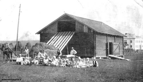 Heinätöitä Sakkolan kunnalliskodin pellolla Karjalassa
Kuva on otettu Karjalassa entisessä Sakkolan pitäjässä kunnalliskodin tiluksilla. Vuonna 1930 valmistunut kunnalliskoti on vaalea rakennus kuvan oikeassa reunassa. Vuonna 1935 aloitti Sakkolan kunnalliskodin tilanhoitajana Kaarlo Heinonen. Hän oli tätä ennen Nivalan kunnalliskodin tilanhoitajana. Heinoset (Kaarlo ja Veera) jättivät Sakkolan kunnalliskodin 1938 ja kiittivät saamistaan lahjoista (Käkisalmen Sanomat 20.8.1938 nro 93). Kunnalliskodin päärakennus on edelleen pystyssä, mutta rapistuneena. 
Keywords: Heinonen Sakkola 