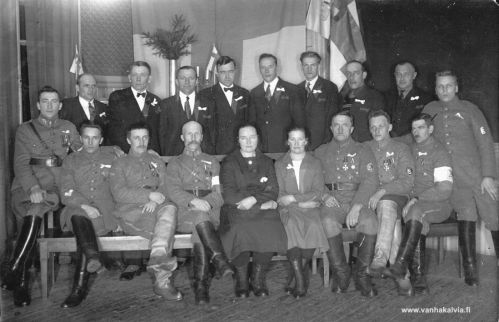 Vapaussodan muistojuhla Kälviällä 1928
Vapaussotaan v. 1918 osaa ottaneet kälviäläiset vapaaehtoiset kokoontuneina rintamalle lähdön 10-vuotisjuhlaan Kälviän seurojentalolle 19.2.1928.
Istumassa vas. Ilmari Asujamaa, Ilmari Hautala, Kalle Pirkola, Jalmari Pernu, Selma Muhonen, Signe Tikanoja, Jalmari Marttila, Vilhart Riippa, Väinö Asujamaa, Väinö Porkola.
Seisomassa: Vesteri Kuorikoski, Emil Miekkoja, Antti Hyyppä, Viljo Tikanoja, Niilo Suonperä, Aarne Huhtala, Väinö Autio, Valdemar Tikanoja. Kuvasta puuttuu useita, jotka eivät voineet saapua juhlaan. Tiedot kirjoittanut kuvan taakse Valfrid Raitala.

Keywords: Asujamaa Hautala Pirkola Pernu Muhonen Tikanoja Marttila Riippa Porkola Kuorikoski Miekkoja Hyyppä Suonperä Huhtala Autio 