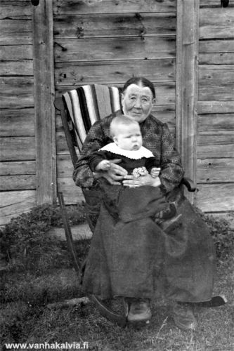 Kiikkutuolissa
Kiikkutuolissa näyttäisi istuvan Anna Liisa Maunumäki (1840-1922, Maunumäki 32). Lapsi on luultavasti joku hänen lapsenlapsistaan, nimi ei ole tiedossa.
Juuret Kälviällä II -kirjassa mummun nimi on Maija Liisa, mutta hänen poikansa Vernerin kuva-albumissa nimi on Anna Liisa. Kts. myös kuva Heinäaikaan Maunumäellä.
Keywords: Maunumäki