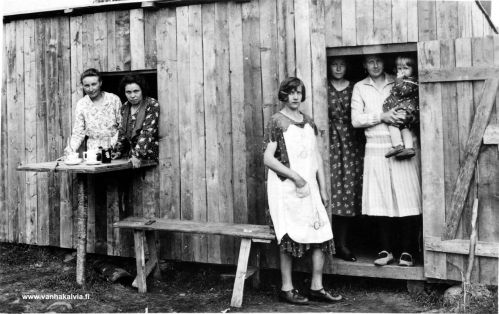 Kioski Peitsolla
Kuva esittää Kuikkisenojan kaivuutyömaan lähellä ollutta kioskia. Mukana kuvassa ovat Martta Vierimaa, Kotkan sisarukset, Maija Karikka ja Olga Peitso sylissään Helli Rimpioja. Vuosi on 1932. 
Keywords: Kuikkisenoja Peitso Vierimaa Kotka Karikka Rimpioja