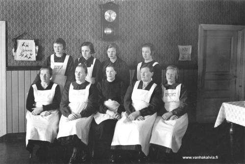 Hautajaiskokkeja?
Kokkeja ryhmäkuvassa. Kenen tupaan on kokoonnuttu ja mistä syystä? Olisiko hautajaiset kyseessä? Maunumäen kinkeripiirissä ollaan todennäköisesti, sillä kuva on Fanny Maunumäen albumista.

Takana ovat vas. Helvi Maajärvi (o.s. Pernu, s. 1919, Pernu 51), Laina Maajärvi, Tyyne Kourijärvi (Kourijärvi 25) ja Siiri Kourijärvi (o.s. Ojala, Kourijärvi 25). 
Edessä vas. Sigrid Herronen (o.s. Parantala, s. 1912, Syväjärvi 17), Katri Syväjärvi, Salli Korpisalo, Jenny Nissi ja Sylvi Pernu (Pernu 51).


Keywords: Maunumäki Kourijärvi Herronen Maajärvi Pernu Ojala Herronen Syväjärvi Korpisalo Nissi Parantala 