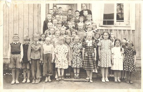 Koululaiset Lottakahvilassa 1951
Kälviän ekaluokkalaisia ryhmäkuvassa. Kuvauspaikka on Lottakahvila ja opettaja on Lempi Huhtala (o.s. Kärävä), kauppias Jalmari Huhtalan puoliso (Huhtala 13). Toiselle luokalle siirryttäessä opettajana oli Sirkka-Liisa Kerola (Kerola 24). Takana vas: Arvo Jantunen, tunnistamaton, Erkki Myllykangas, Seppo Nurisalo, Kari Ingalsuo ja Kari Saarinen.
Seuraava rivi vas: Tunnistamaton, Erkki Mäkelä, Alpo Rautomäki, Matti Konola, Esko Hiltunen ja Erkki Peitso.
Seuraava rivi vas: Heikki Porkola, Simo Hietala, Olavi Rauhala, Marja-Liisa Nurila, Jukka-Pekka Hietala ja Kaisu Lassila.
Välissä vas: Soile Hietala, Eija Hautamäki, tunnistamaton, tunnistamaton, Leena Mäkelä, ? Vuorinen, Tuula Hjelm, Marja Höri ja Ulla Särkkö.
Edessä vas: Seppo Saajoranta, Kauko Lassila, Pentti Myllykangas, Jaakko Hietala, Raija Närväinen, Eila Mäkelä, Raija Järvinen, Leena Rannisto, Leena Pivo, Leena Roimela ja Sinikka Rimpioja. Jos tunnistat lisää koululaisia, lähettäisitkö viestin osoitteeseen vanhat.kuvat@vanhakalvia.fi  Kiitos avustasi!
Keywords: Huhtala Kärävä Kerola 