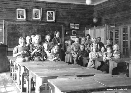 Käsityötunnilla
Junnolan Riku on käynyt ottamassa kuvan Ruotsalon koulun käsityötunnilla keväällä 1946. Lapset tekevät käsitöitään ja aurinko paistaa ikkunasta sisälle. Liitutaulun yläpuolelle on ripustettu kolmen presidentin kuvat. Opettajana on Sinikka Järvi (m. Kalske, Järvi 24). 

Edessä vas. pulpetilla istuu Anni Junka ja vieressä Aila Kuusiniemi. Heidän keskellä taaempana Salme Vehkala. Vain vähän kasvoja näkyy takana istuvasta Terttu Lampelasta, hän oli Sallan evakkoperheen lapsia. Edessä rusettipäinen istuva ja kutova tyttö on Terttu Harju ja hänen vas. puolella Pirkko Kerola. Opettajan vas.puolella Terttu Saari
.
Oik. puoleisessa ryhmässä takana vas. Aila Järvi, Antti Kinnari, Erkki Pietilä ja tummahiuksinen tyttö takana Anna-Liisa Matinjussi. Istuva poika edessä myöskin Sallan evakkoperheen poika Jussi Siivola. Vaalea rusetti hiuksissa Anna-Liisa Hakunti ja hänen oik. puolella Arvo Peitso ja Eila Kolehmainen. Edessä istuvat tytöt vas. Anni Järvi, Helvi tai Tyyne Ylitalo Sallasta, tummahiuksinen tyttö Anni Kinnari ja oik. Ritva Rimmi. Tiedot Anni Hakunti (o.s. Järvi) 

Keywords: Järvi Hakunti Junka Kuusiniemi Vehkala Lampela Harju Kerola Saari Kinnari Pietilä Matinjussi Siivola Peitso Kolehmainen Ylitalo Rimmi Kalske Salla 