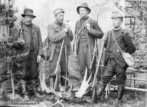 Metsästäjät
Kuvassa kälviäläiset metsästyskaverit Jukka Huhta, Vilho Tapio (ent. Renell), Valfrid Raitala ja Jalmari Pernu. Kuva on vuoden 1906 tietämiltä. Saaliina oli hirvi, jonka sarvet ovat kuvassa.  Hirvi ammuttiin Vilho Tapion ja Jalmari Pernun yhteislaukauksella. 

Kiväärit ovat Craftoneita, eli oikeilta nimeltään Wetterli. Crafton-nimen aseet saivat siitä, että ne salakuljetettiin Crafton-nimisellä aluksella Kokkolan ja Pietarsaaren rannikkoseudulle. Loppujen lopuksi alus jouduttiin räjäyttämään paljastumisen pelossa. Kälviällä tiedetään olleen 5 kpl Craftoneita. Näiden lisäksi yksi oli asemapäällikkö Löfmanilla, joka sittemmin luovutti aseensa vapaussodan alussa Kokkolaa vapauttamaan lähteneille miehille. 

Kuvalle on olemassa "sisarkappale" Kälviän ja Ullavan kirjassa, jossa miehet ovat vasta menossa jahtiin. Onkohan kuva samalta reissulta mahdollisesti?

Keywords: Huhta Tapio Renell Raitala Pernu 