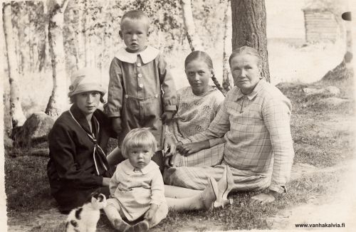 Kustin Hanna ja lapset
Kuvassa on Hanna Aho, Kustin Hanna eli Priita Johanna Antintytär Aho (1874-1943, Huhtan mäkitupa). Hannan mies Kusti rakensi tupansa uittopuista, jotka oli sukeltanut joen pohjasta. 
Hanna muutti kolmen lapsensa kanssa Ullavalta Kälviälle 1920-luvulla. Kuvassa ovat Hannan lapsista takana seisova pikkupoika Vilho Kustaa (s. 1912). Hän kaatui talvisodassa Pitkärannassa 5.2.1940. Lettipäinen tyttö on Aune (s. 1905). Hän meni naimisiin Puikolle. Edessä oleva pikkuinen on Valma (s. 1916). Valma kuoli nuorena, jo v. 1931. Vasemmalla istuva hattupäinen nuori nainen on vielä tunnistamatta. Hän ei kumminkaan ole Hannan lapsia. Juuret Kälviällä -kirjassa Hannan lapsista mainitaan vain Vilho Kustaa, mutta kuvassa olevien lisäksi Hannalla oli vielä poika Johan Edvart eli Hannes. 
Kuvan on ottanut Jukka Hakala, kuvausaika ehkä noin 1917-18 tienoilla. 


Keywords: Aho Hakala