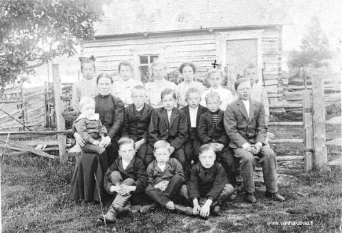 Pyhäkoulu Järvellä, Ruotsalolla
Pyhäkoulun opettaja Brita Johanna Järvi (Järvi 24, Juuret Kälviällä 2, s. 660) istumassa lapsi sylissään. Brita Johannan poika Ernst Järvi penkin päässä oikealla. Ylärivissä vasemmalla Aili Porko (Porko 13, Juuret Kälviällä 2, s. 665). Ylärivissä kolmantena oikealta  Lyyli Järvi (Järvi 25, Juuret Kälviällä 2, s. 660-661). Muita lapsia ei ole tunnistettu.
Pyhäkoululaisten takana olevassa rakennuksessa oli Antti Järven ensimmäinen kauppa Ruotsalolla. Rakennus on nykyään nähtävissä Kälviällä Toivosen Talonpojan Museossa. Museossa se on tunnuksella "Torppa" ja  mukana on kyltti "Kauppa Antti Järvi". 
Kaupan takana siintelee Isojärvi. Kuva on otettu vuoden 1908 tienoilla.
Keywords: Järvi Porko
