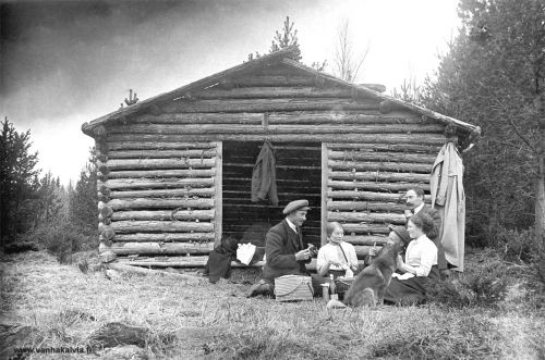 Retkellä kevätpäivänä
Kuvan takana on päiväys 1.5.1913. Eväskoreihin on pakattu ainakin limonadia ja voileipiä. Retkieväitä nauttivat ladon oviaukon vieressä istuva Esteri Penttilä (Penttilä 27), hattupäinen Jalmari Pernu (Pernu 38) ja oikealla opettaja Matti Karhulahti (Karhulahti 25). Toinen naisista näyttäisi olevan Nelma Pernu (o.s. Porri, Porri 24), Jalmari Pernun tuleva vaimo. Vasemmanpuoleinen mieshenkilö on vielä tunnistamatta. 
Olisiko retki tehty Kunnarinpauhaan? Kuva Kunnarinpauhassa 1938 näyttäisi olevan otettu samalla paikalla. Puut vain ovat kasvaneet suuremmiksi ladon ympärillä.
Keywords: Penttilä Pernu Karhulahti Porri