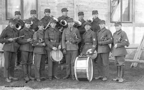 Suojeluskunnan torvisoittokunta 29.4.1929
Takana vas. Vilho Porrassalmi, Viljo Hietaharju, Veikko Hyyppä, Yrjö Koittola, Into Asujamaa, Pykälämaa.
Edessä vas. Paavo Mäkelä, Pauli Vähälä, Ilmari Koittola, Lauri Nurila, Huvi Alestalo, rummun takana Usko Porrassalmi, Reino Mäkelä, Eino Huhtala.
Kuvaaja Riku Junnola.

Keywords: Porrassalmi Hietaharju Hyyppä Koittola Asujamaa Pykälämaa Mäkelä Vähälä Nurila Alestalo Porrassalmi Huhtala Junnola