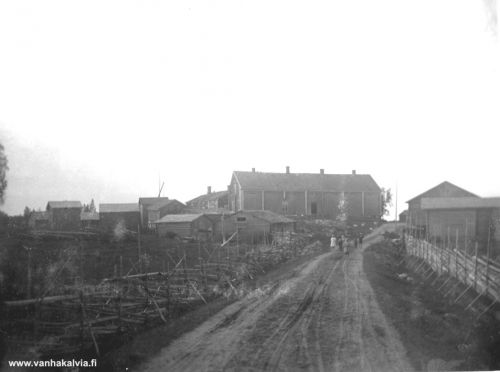 Tie Peitsolle
Vuodelta 1910 peräisin olevassa kuvassa näkyy Peitson taloja ja muita rakennuksia. Peitson suuri, nelipiippuinen vanha sukutalo purettiin 1800-luvun lopulla. Talon hirsiä käytettiin Peitson kolmen uudemman talon rakennushirsinä Topolassa ja kahdessa muussa Peitson talossa rantatien toisella puolella. Kuvassa näkyy myös nelipiippuinen rakennus. Se lienee jokin toinen Peitson monista asuintaloista ja rakennuksista.

Keywords: Peitso