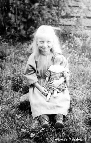 Tyttö ja tokku
Kukahan on tämä iloinen pikkutyttö nukkensa kanssa? Kuva on Fanny Maunumäen albumista.
Kuvaajana on ollut Jukka Hakala ja kuva saattaa ehkä olla 1920-luvulta.
