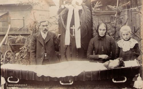 Omaiset Salomon Rytikankaan eli Rinellin arkun äärellä
Salomon Rytikangas syntyi Kälviällä 10.4.1856. Hän oli Rytikankaan sisaruksista nuorin. Salomon lähti työhön Viipuriin, jossa avioitui Maria Helena Kronholmin kanssa. Maria oli syntynyt Lohtajalla. Kerrotaan, että he olivat tutustuneet jo Pohjanmaalla. Heille syntyi kaksi lasta Juho Leonard s. 8.6.1880 ja Elsa Maria s. 21.2.1893. Viipurissa sukunimi vaihtui nimeksi Rinell. Salomon Rytikangas eli Rinell kuoli 49-vuotiaana 28.10.1905. Hänet on haudattu Ristimäen vanhalle hautausmaalle Viipurissa. 
Kuvassa Salomonin perhe arkun äärellä. Onko kuvan viiksekäs mies hänen poikansa Leonard Rinell? Kuvanottohetkellä hän olisi ollut 25-vuotias. Mies vaikuttaa vanhemmalta, mutta kuvaa suurentamalla huomataan, että hän on vielä melko solakka, hänellä on täysi tukka, rypytön otsa, rypyttömät silmän alukset, ja ehkä kuitenkin nuoren miehen viikset? Miksi, joku hautausurakoitsija tai palkollinen olisi jäänyt kuvaan? Ehkä siis sittenkin ”Leunartti”? Kuvan muut henkilöt ovat leski Maria Helena Rinell s. Kronholm (s. 1.8.1853) ja tytär Elsa Maria (s. 21.2.1893). 
Kuvan omistaa Hannu Suvensalmi Hyvinkäältä. Hän on Salomon Rytikankaan tyttären tyttärenpoika.
Keywords: Rytikangas Kronholm Rinell Lohtaja Viipuri Ristimäki 