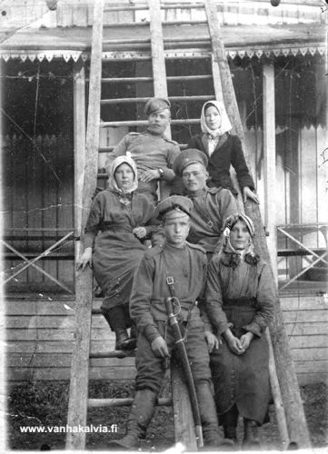 Tytöt ja venäläiset sotapojat Kräneessä
Granö, eli ruotsalolaisittain Kränee, oli 1700-luvulla perustettu tila, jossa oli komea, kartanomainen päärakennus. Aina 1830-luvulta vuoteen 1917 se oli sotilaskäytössä venäläisten vartioasemana. Perimätiedon mukaan yhteiselo ruotsalolaisten ja vierasmaalaisten sotilaiden välillä oli sopuisaa ja rauhallista, mitä kuvakin todistaa. Se on otettu Granön päärakennuksen takana noin 1915.  Ylinnä oikealla Lyyli Järvi, (kauppias Antti Järven tytär, s. 1899, Järvi 25), vasemmalla Meimi Pelttari (Juho ja Hilma Sofia Pelttarin tytär, s. 1899, Kerola 27). Meimi muutti isänsä kanssa pysyvästi Amerikkaan vuonna 1925. Edessä oikealla on Hilja Pelttari (myöh. Kerola, s. 1899, Pelttari 21). Sotilaiden nimet eivät ole tiedossa. 
Keywords: Granö Järvi Pelttari Kerola