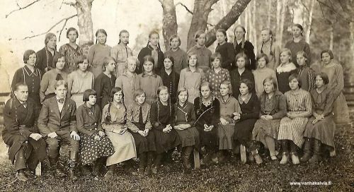 Rippikoululaisia 1933
Rippikoulutyttöjä vuodelta 1933 yhteiskuvassa. Tytöt ovat Suomi-neidon ikätovereita, syntyneet 1917. Nuorempi mies toisena vasemmalta on vt kirkkoherra Jorma Sipilä, Hille Sipilän poika, joka toimi isänsä kuoleman jälkeen Hille Sipilän lesken ja äitinsä Annin ensimmäisen armovuoden saarnaajana (Kumpula 24). Vasemmassa reunassa istuva mies on tunnistamatta, luultavasti hän on kanttori.
Ensimmäisessä rivissä vas. 5. Anna Mäkelä (Mäkelä 32). Toisessa rivissä vas. 1. Hellin Kotkajuuri (s. 1917, myöh. Porrassalmi, Hietakangas 4) ja vieressä serkkunsa Helmi Kivilehto (s. 1917, myöh. Strang, Yritys 6). Kuvassa on myös kolmas serkus Yritys 7:stä. Hän on Alma Maria Kotkajuuri  (myöh. Nyblom s.1917). keskirivissä 5. vasemmalta, vaaleatukkainen tyttö. Kuvassa tiedetään olevan myös monien kälviäläisten tuntema kauppias Anja Vähähyyppä, mutta missä? Tunnistaisiko joku hänet?.Jos kuvassa on tuttuja henkilöitä, lähettäisitkö viestin Vanhan Kälviän sähköpostiin. Kiitos avustasi!
Keywords: Sipilä Mäkelä Kotkajuuri Porrassalmi Kivilehto Strang Nyblom Vähähyyppä